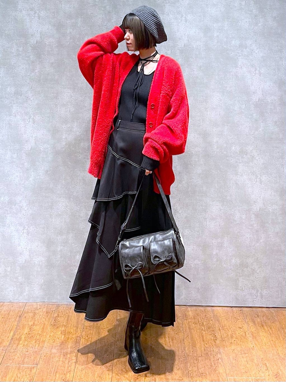 ブラック系のショルダーバッグ、ブラック系のブーツ、ブラック系のスカートを着用したレディースの秋コーディネートの1枚目の写真