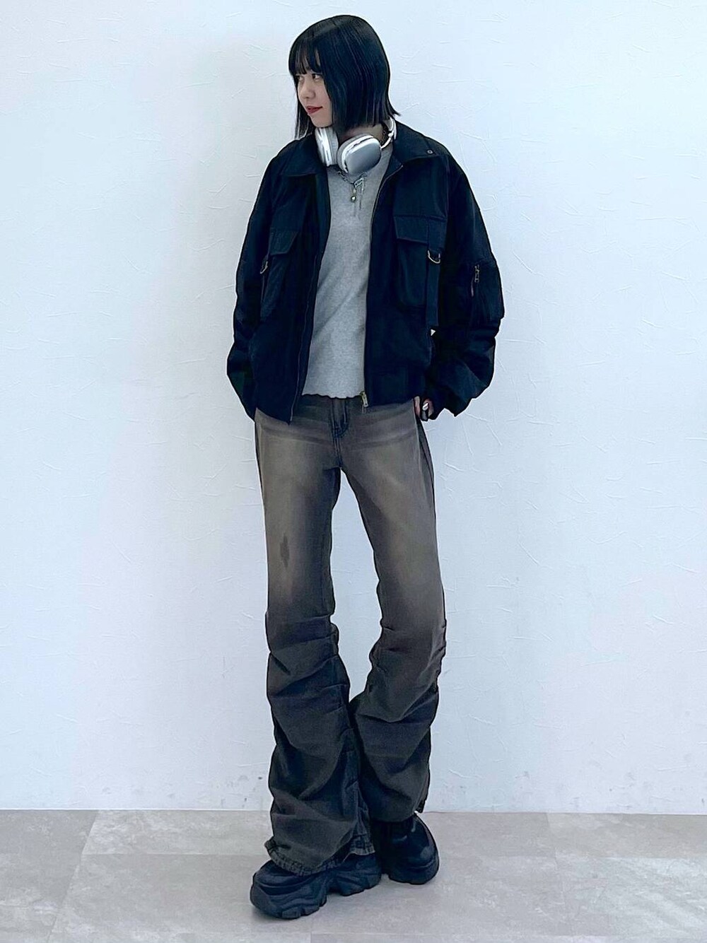 ブラック系のスニーカー、ブラック系のデニムパンツ、グレー系のTシャツ/カットソーを着用したレディースの秋コーディネートの1枚目の写真