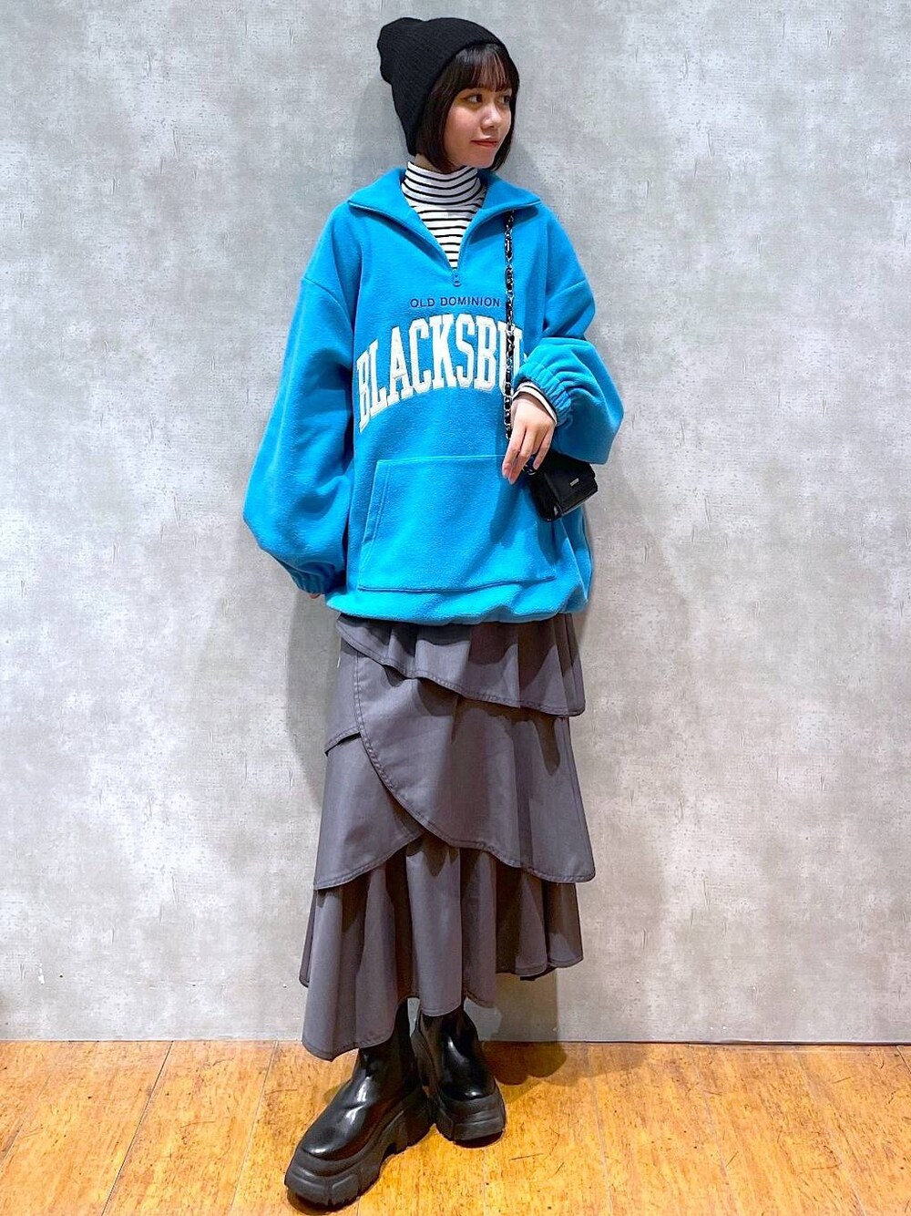 ブラック系のブーツ、グレー系のスカート、ホワイト系のTシャツ/カットソーを着用したレディースの冬コーディネートの1枚目の写真