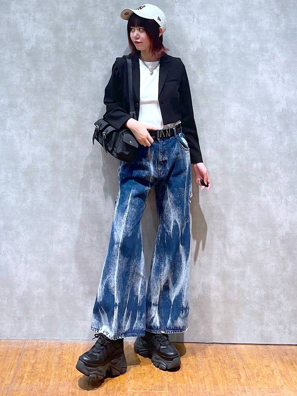 ブラック系のショルダーバッグ、ブラック系のスニーカー、ブラック系のテーラードジャケットを着用したレディースの春コーディネートの1枚目の写真