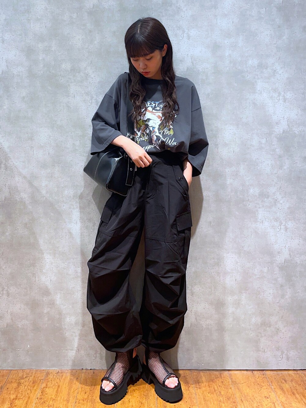 グレー系のTシャツ/カットソー、ブラック系のショルダーバッグ、ブラック系のスラックスを着用したレディースの夏コーディネートの1枚目の写真