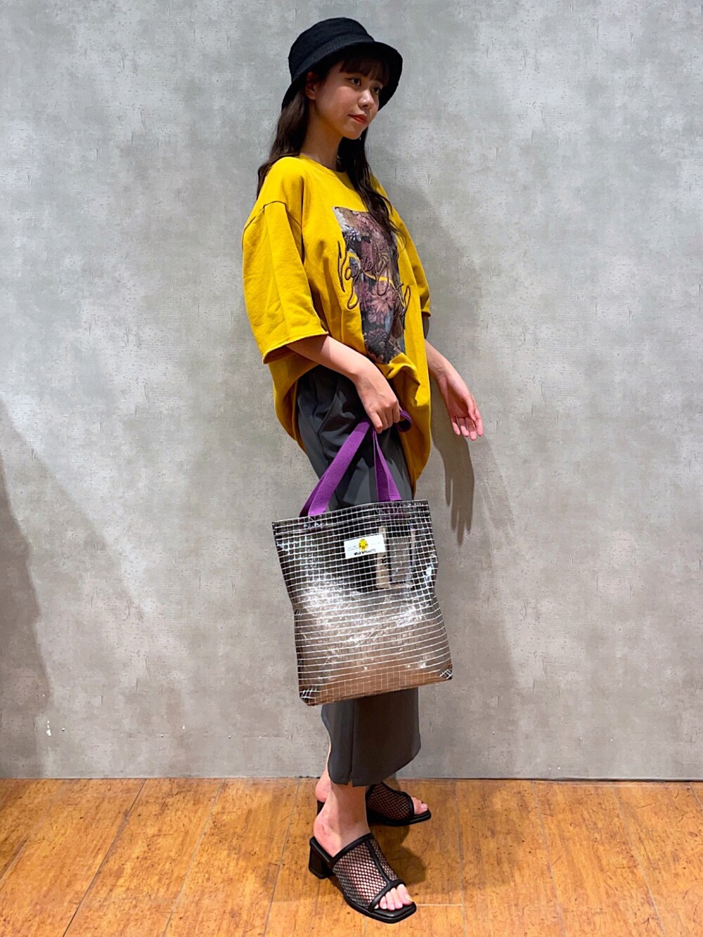 イエロー系のTシャツ/カットソー、グリーン系のトートバッグ、グレー系のスカートを着用したレディースの夏コーディネートの1枚目の写真