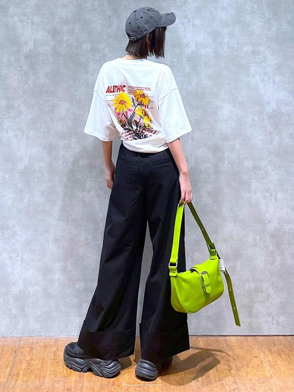 ブラック系のスニーカー、ホワイト系のTシャツ/カットソー、グリーン系のショルダーバッグを着用したレディースの夏コーディネートの1枚目の写真