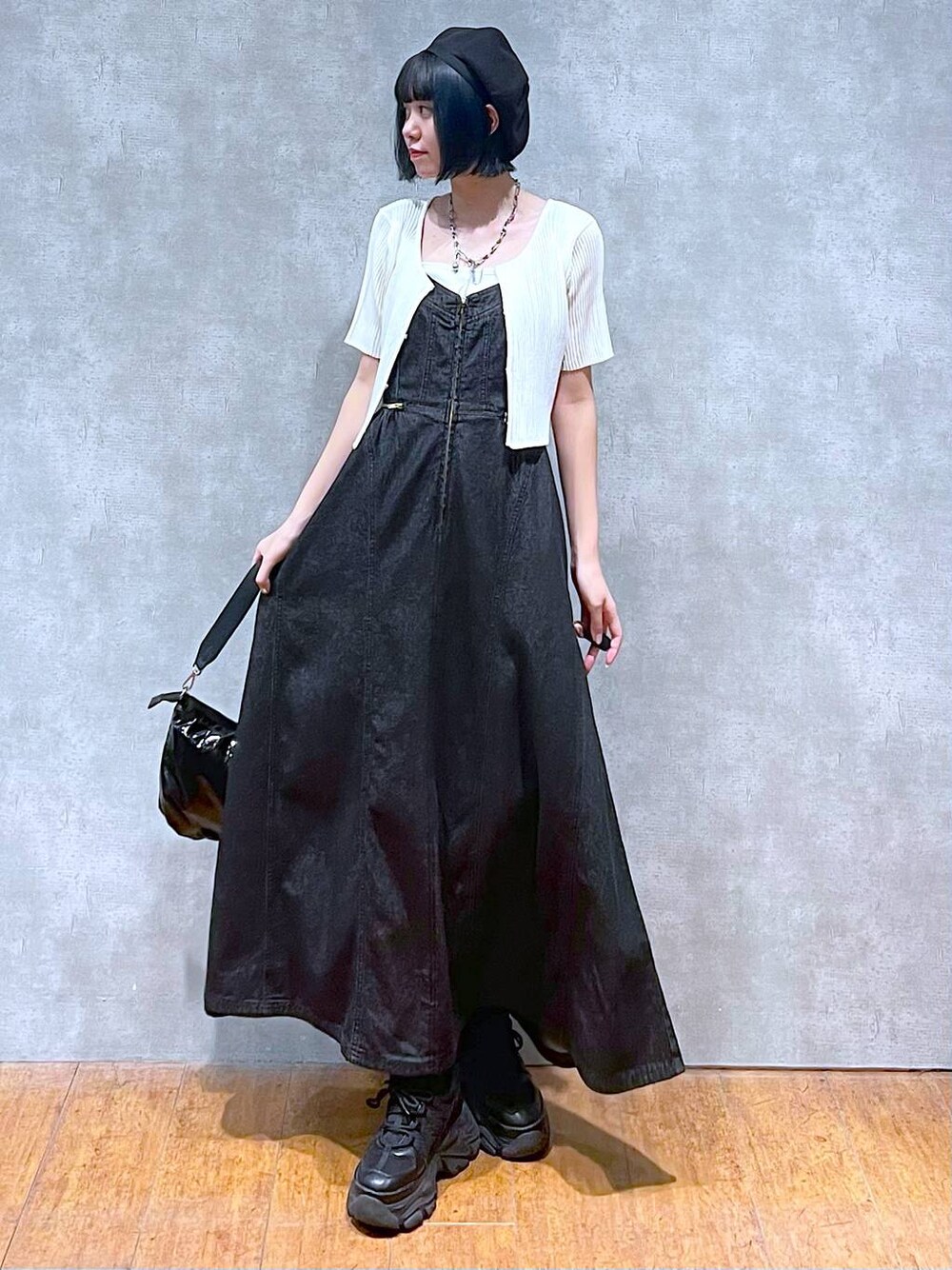 ブラック系のスニーカー、ブラック系のワンピース、ホワイト系のキャミソールを着用したレディースの夏コーディネートの1枚目の写真