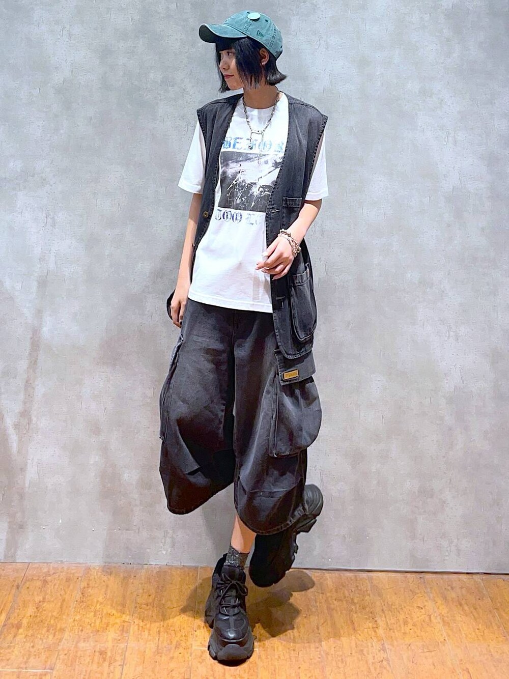 ブラック系のスニーカー、ホワイト系のTシャツ/カットソー、ブラック系のデニムパンツを着用したレディースの夏コーディネートの1枚目の写真