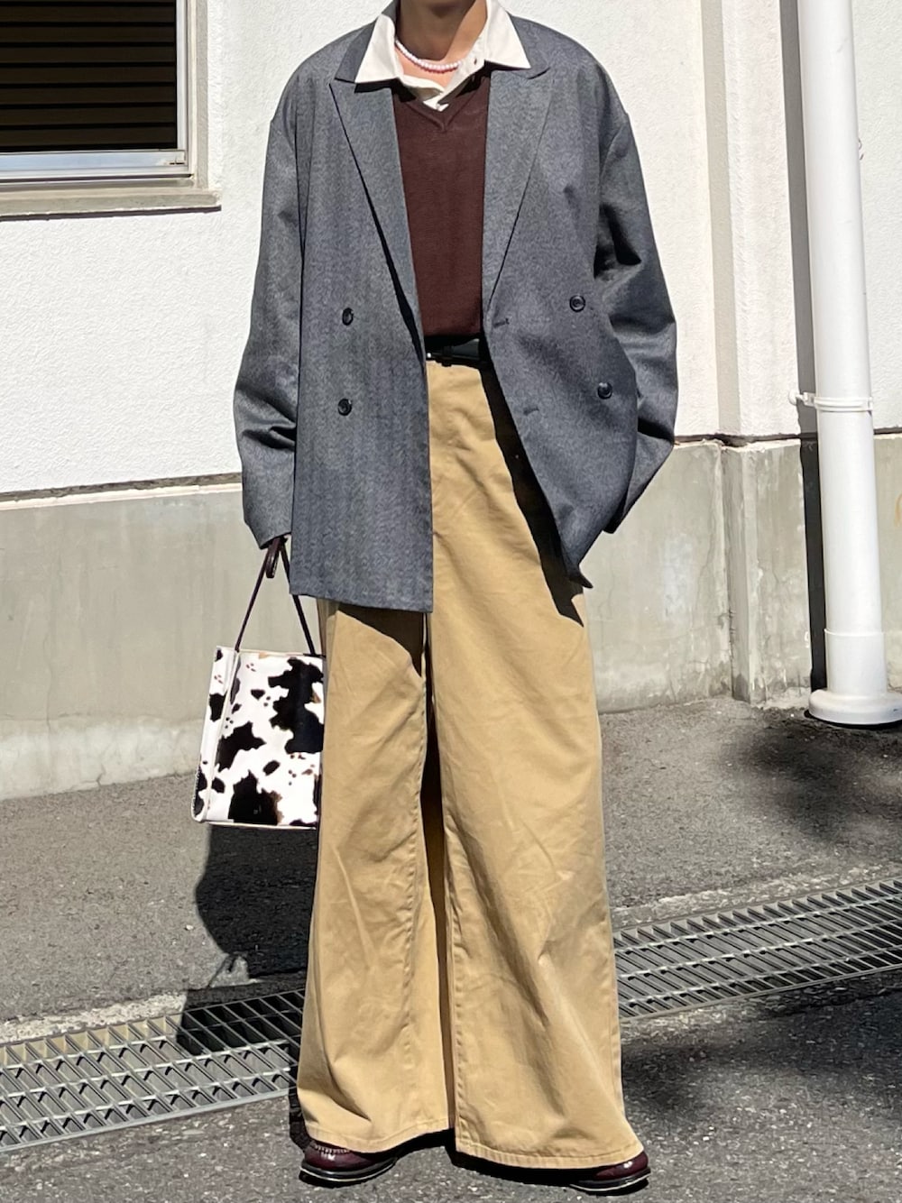 グレー系のテーラードジャケット、ベージュ系のチノパンツ、ブラウン系のベストを着用したメンズの秋コーディネートの1枚目の写真