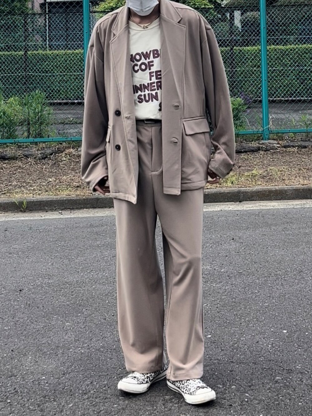 ベージュ系のセットアップ、ベージュ系のTシャツ/カットソー、ホワイト系のスニーカーを着用したメンズの春コーディネートの1枚目の写真