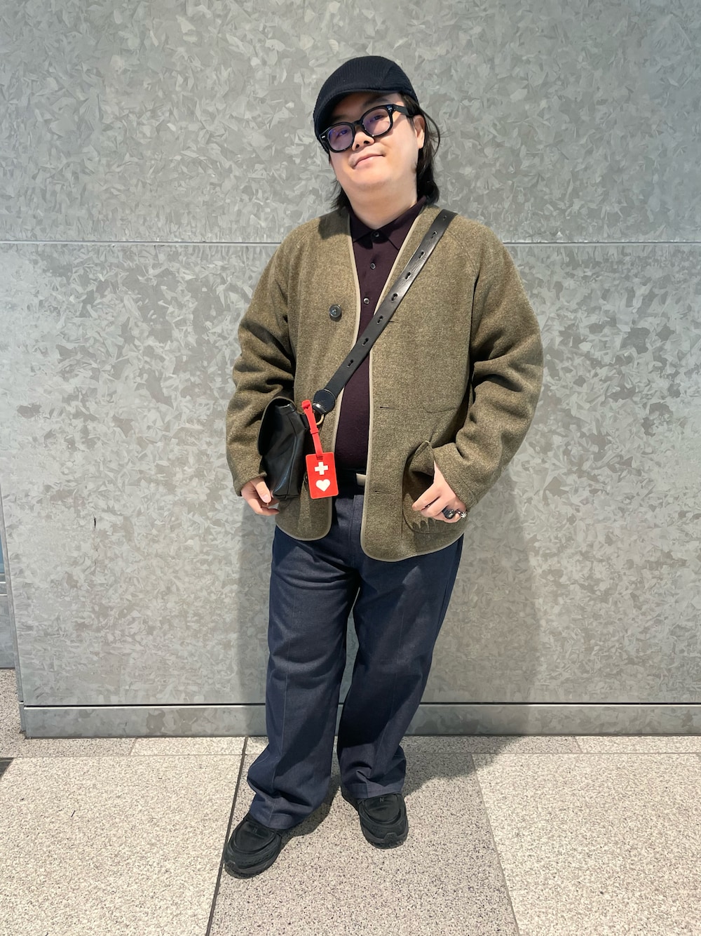 ブルー系のチノパンツ、ブラック系のボディバッグ/ウエストポーチ、パープル系のニット/セーターを着用したメンズの秋コーディネートの1枚目の写真