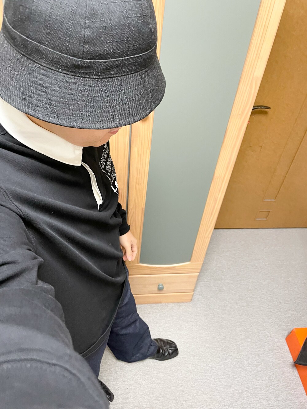 ブラック系のポロシャツ、ブルー系のチノパンツ、ブラック系のその他シューズを着用したメンズの秋コーディネートの1枚目の写真