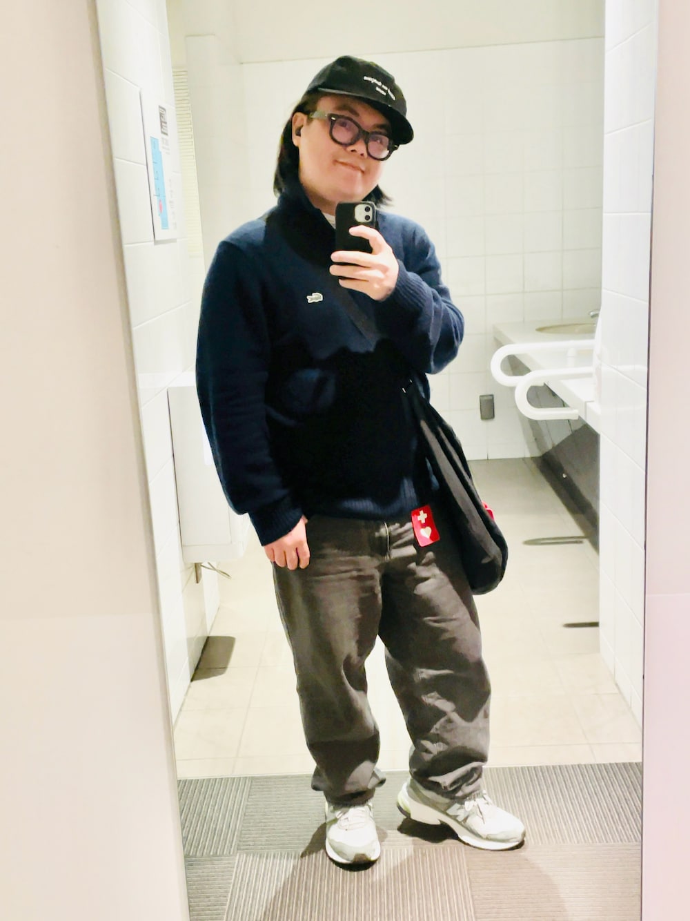 ブルー系のニット/セーター、ブラック系のデニムパンツ、ブラック系のトートバッグを着用したメンズの秋コーディネートの1枚目の写真