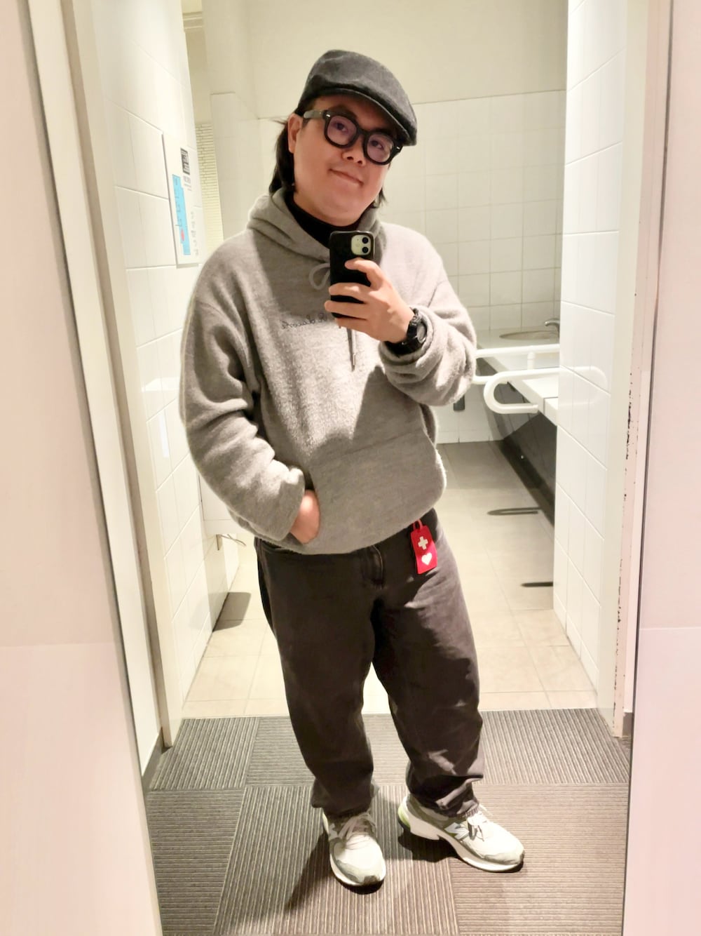 グレー系のパーカー、ブラック系のデニムパンツ、パープル系のTシャツ/カットソーを着用したメンズの秋コーディネートの1枚目の写真