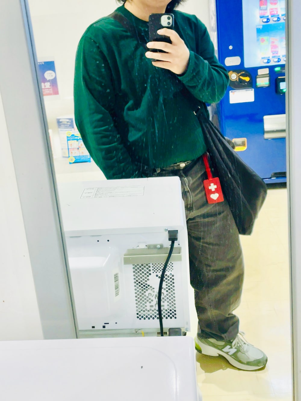 グリーン系のTシャツ/カットソー、ブラック系のデニムパンツ、グリーン系のスニーカーを着用したメンズの秋コーディネートの1枚目の写真