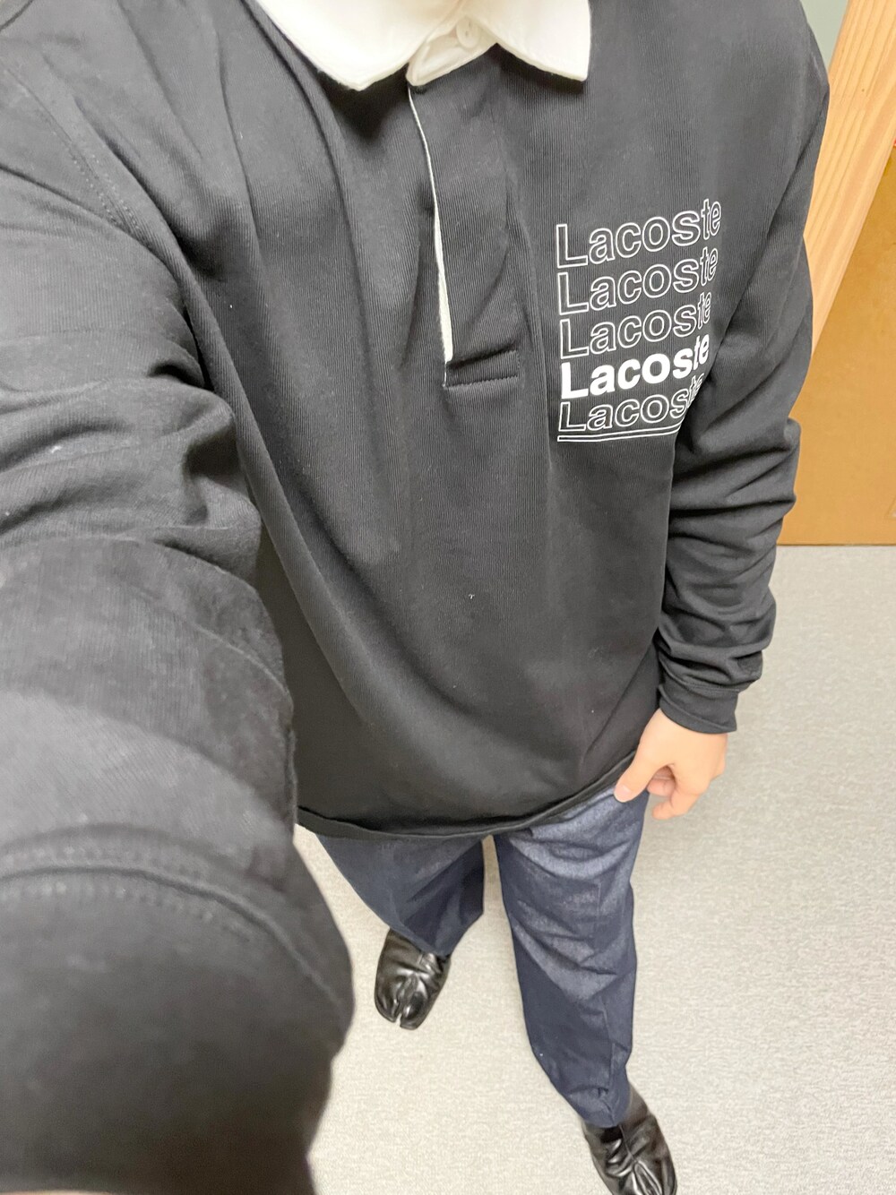 ブラック系のポロシャツ、ブルー系のチノパンツ、ブラック系のその他シューズを着用したメンズの秋コーディネートの1枚目の写真