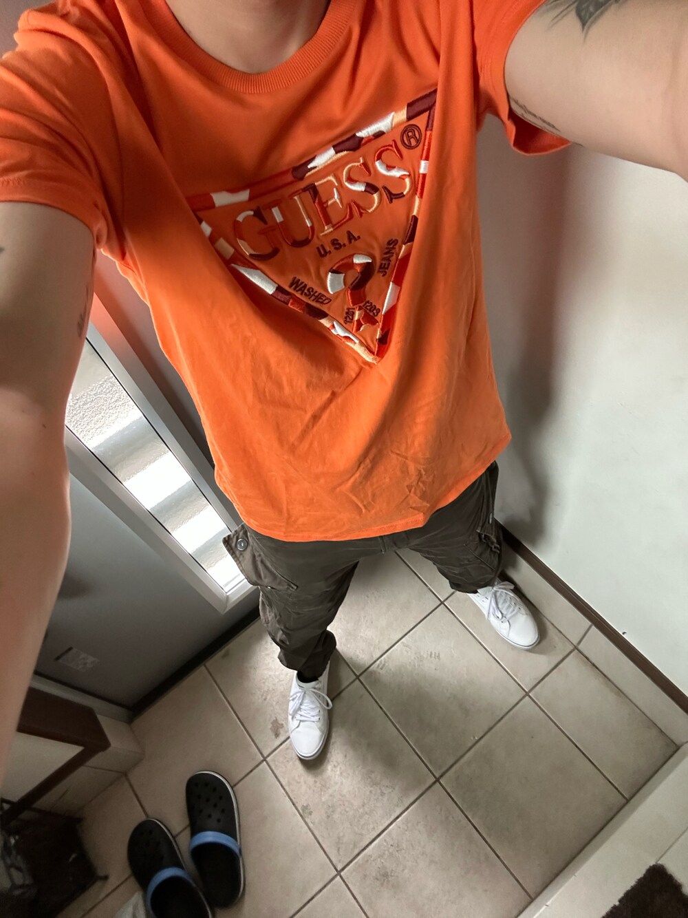 「カジュアル、今日のコーデ、アメカジ、シンプル、カーゴパンツ、Tシャツ、スニーカー、カーキ、オレンジ、ゲス、ジースター・ロゥ(G-STAR RAW)」｜「GuessのGad Tee（Tシャツ/カットソー、オレンジ系）」を使った、ヒーボーさん（メンズ・177cm）の夏コーディネートの1枚目の写真