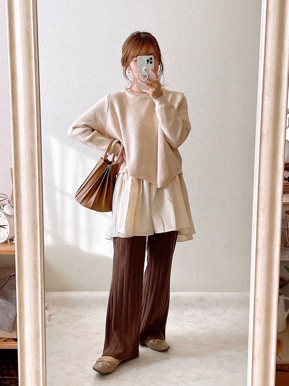 ベージュ系のニット/セーター、ブラウン系のハンドバッグ、ブラウン系のその他パンツを着用したレディースの秋コーディネートの1枚目の写真