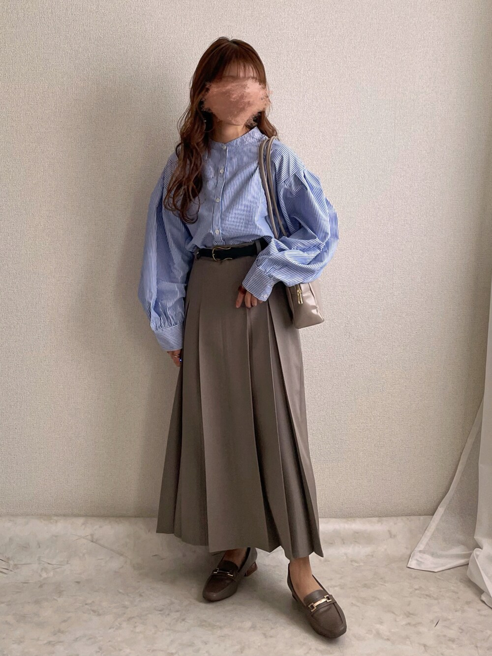 ブルー系のシャツ/ブラウス、ベージュ系のハンドバッグ、グレー系のスカートを着用したレディースの春コーディネートの1枚目の写真