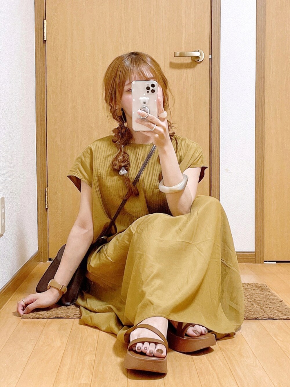 イエロー系のワンピース、ブラウン系のショルダーバッグ、イエロー系のサンダルを着用したレディースの夏コーディネートの1枚目の写真