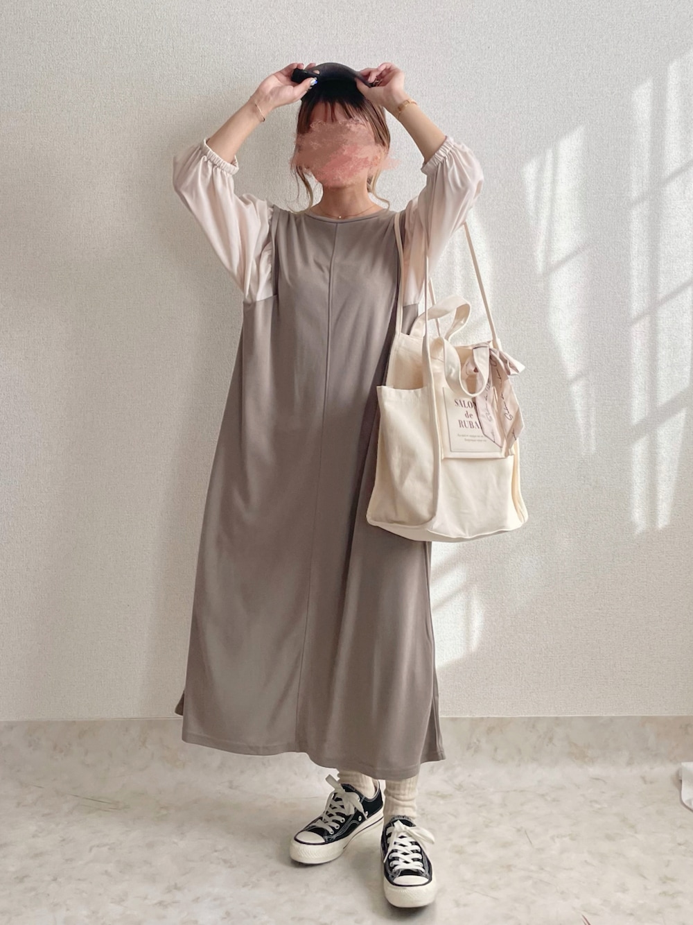 ベージュ系のワンピース、ホワイト系のトートバッグ、ブラック系のスニーカーを着用したレディースの秋コーディネートの1枚目の写真