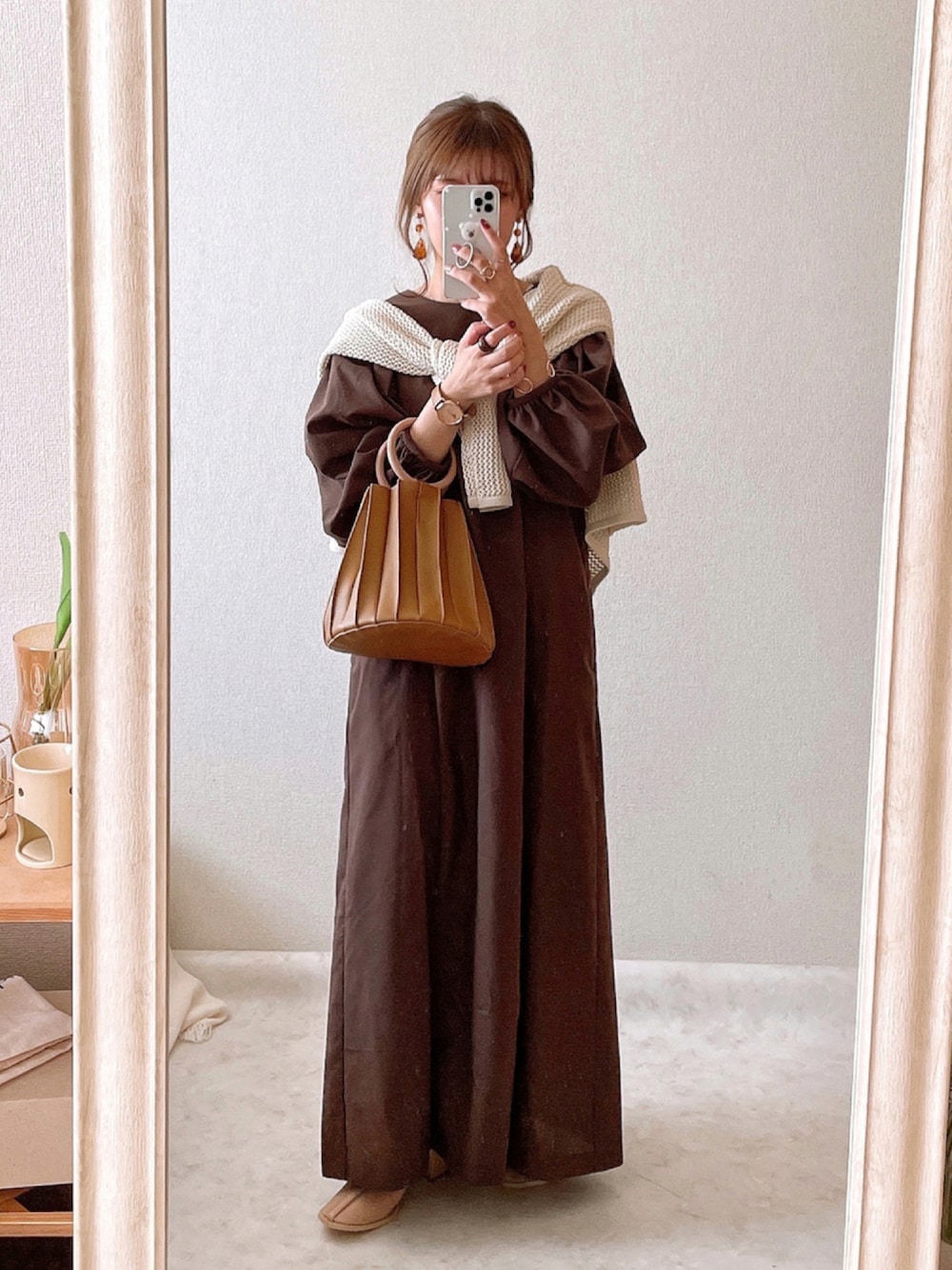 ブラウン系のワンピース、ホワイト系のカーディガン/ボレロ、ブラウン系のハンドバッグを着用したレディースの秋コーディネートの1枚目の写真