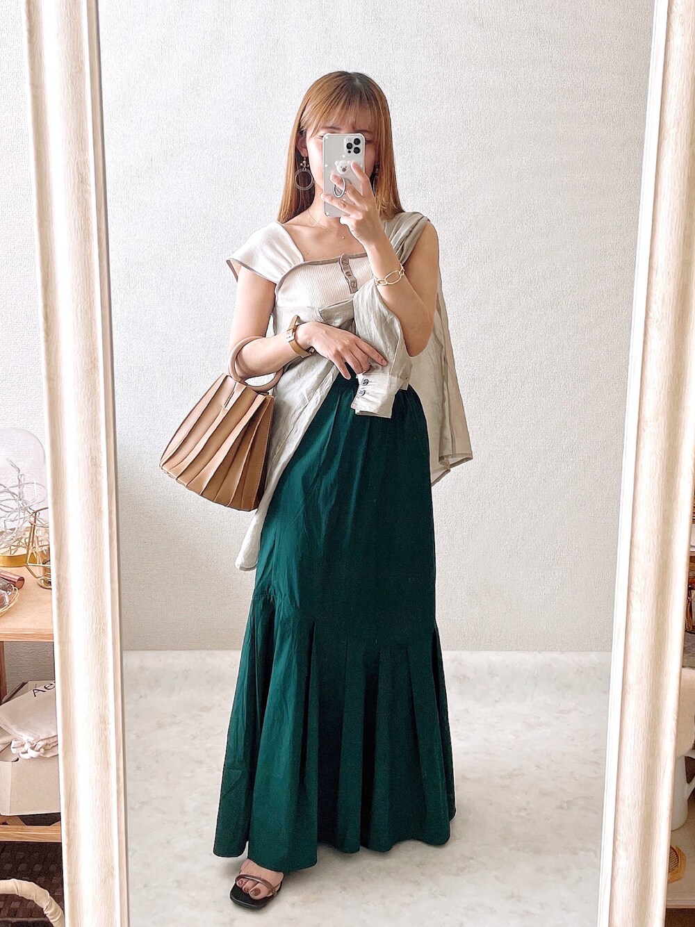 ベージュ系のタンクトップ、ベージュ系のシャツ/ブラウス、ブラウン系のハンドバッグを着用したレディースの夏コーディネートの1枚目の写真