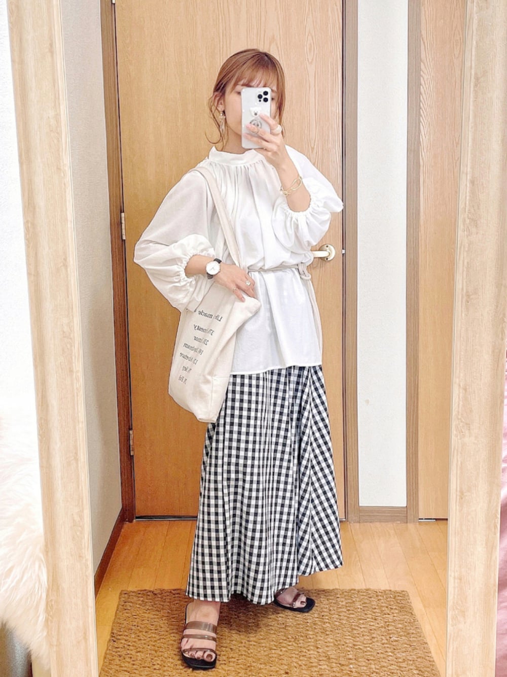 ホワイト系のシャツ/ブラウス、ブラック系のスカート、ホワイト系のトートバッグを着用したレディースの夏コーディネートの1枚目の写真