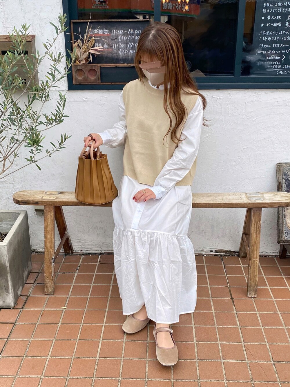ホワイト系のシャツワンピース、ブラウン系のハンドバッグ、ベージュ系のバレエシューズを着用したレディースの秋コーディネートの1枚目の写真