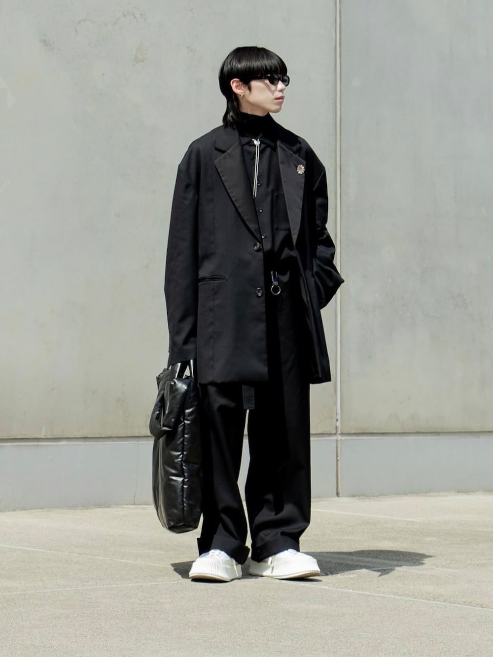 ブラック系のテーラードジャケット、ブラック系のつなぎ/オールインワン、ブラック系のトートバッグを着用したメンズの秋コーディネートの1枚目の写真