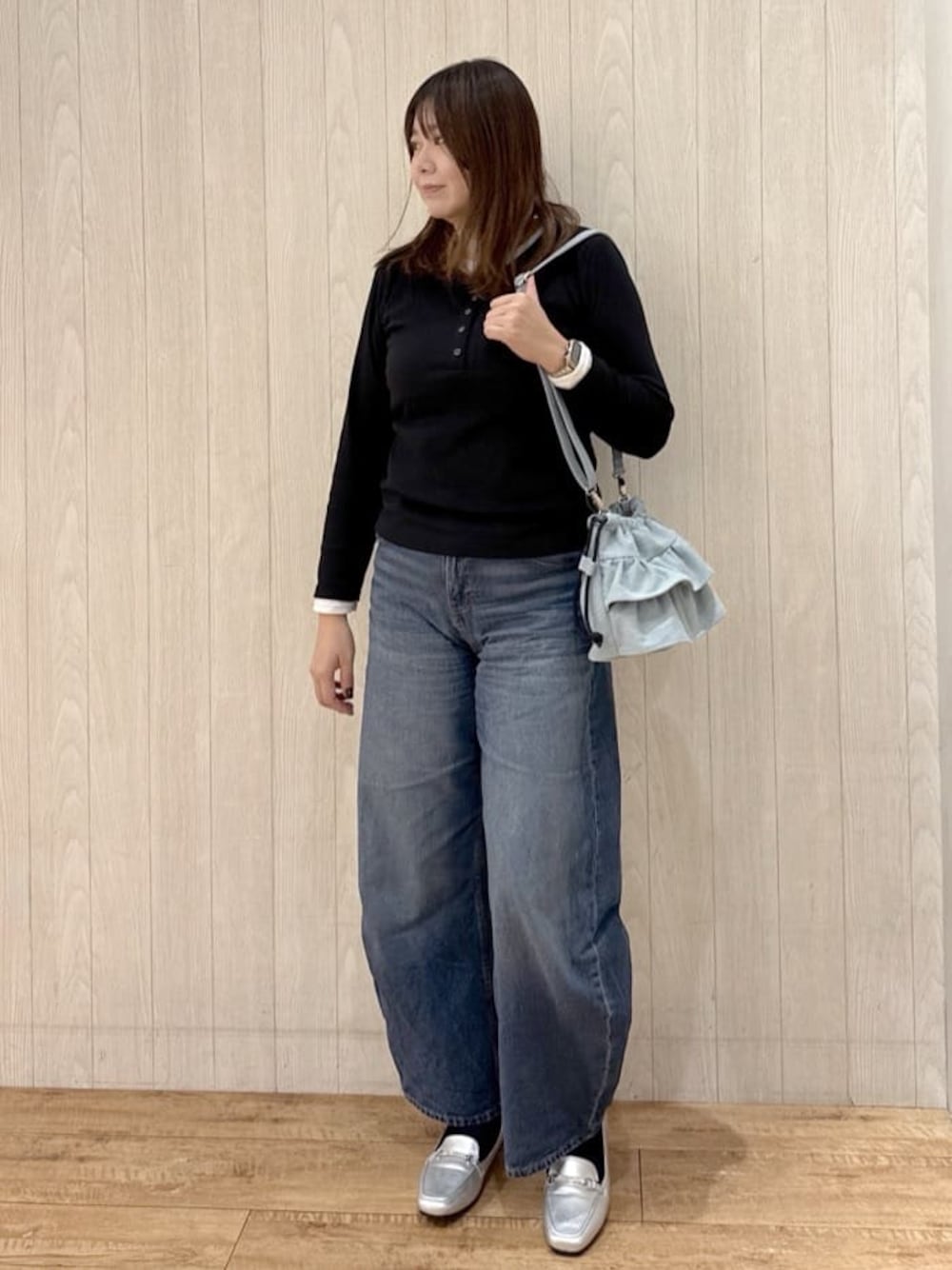 ブラック系のTシャツ/カットソー、ブルー系のデニムパンツ、シルバー系のパンプスを着用したレディースの冬コーディネートの1枚目の写真