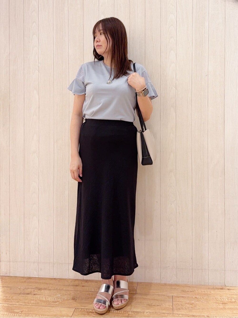 ブルー系のTシャツ/カットソー、ブラック系のスカート、シルバー系のサンダルを着用したレディースの夏コーディネートの1枚目の写真