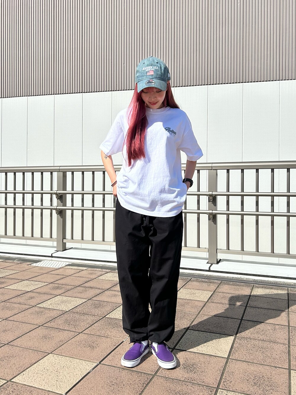 ブラック系のパンツ、ホワイト系のトップス、その他のキャップを着用したレディースの春コーディネートの1枚目の写真