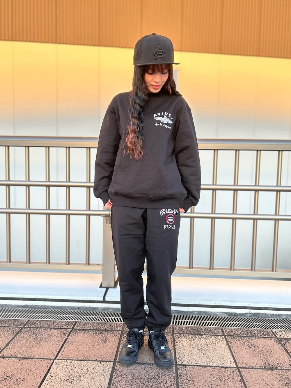 ブラック系のスウェット、ブラック系のスウェットパンツ、ブラック系のキャップを着用したレディースの冬コーディネートの1枚目の写真