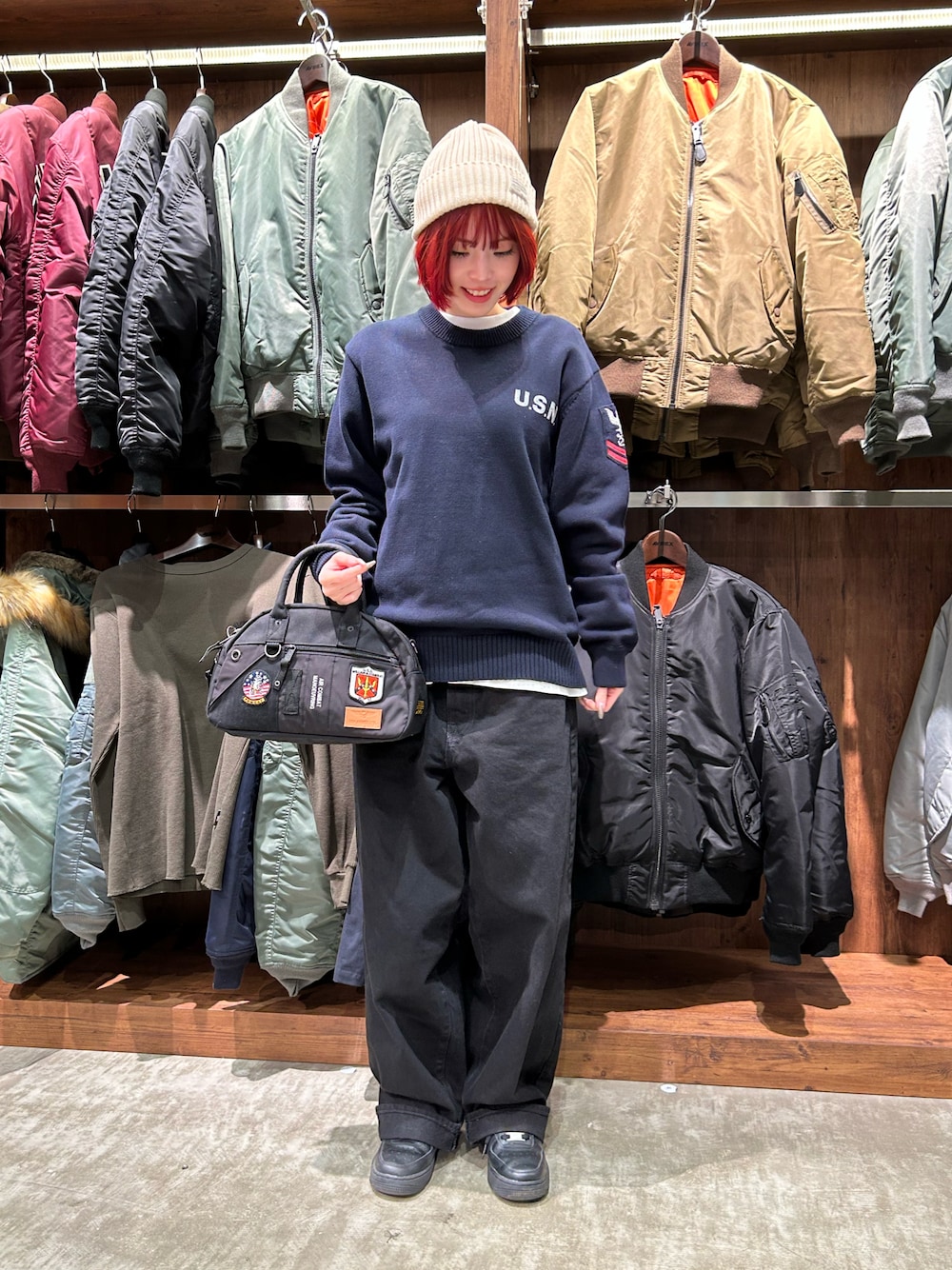 ブルー系のニット/セーター、グリーン系のボストンバッグ、ホワイト系のニットキャップ/ビーニーを着用したレディースの冬コーディネートの1枚目の写真