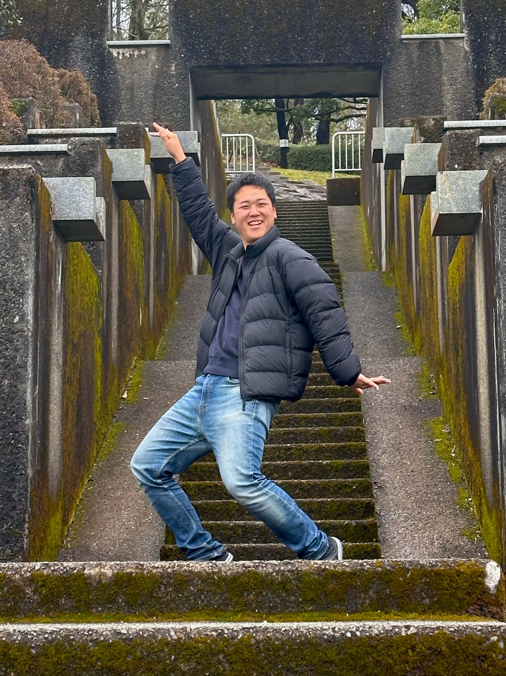 ブルー系のデニムパンツ、ブルー系のニット/セーター、ブラック系のダウンジャケット/コートを着用したメンズの春コーディネートの1枚目の写真