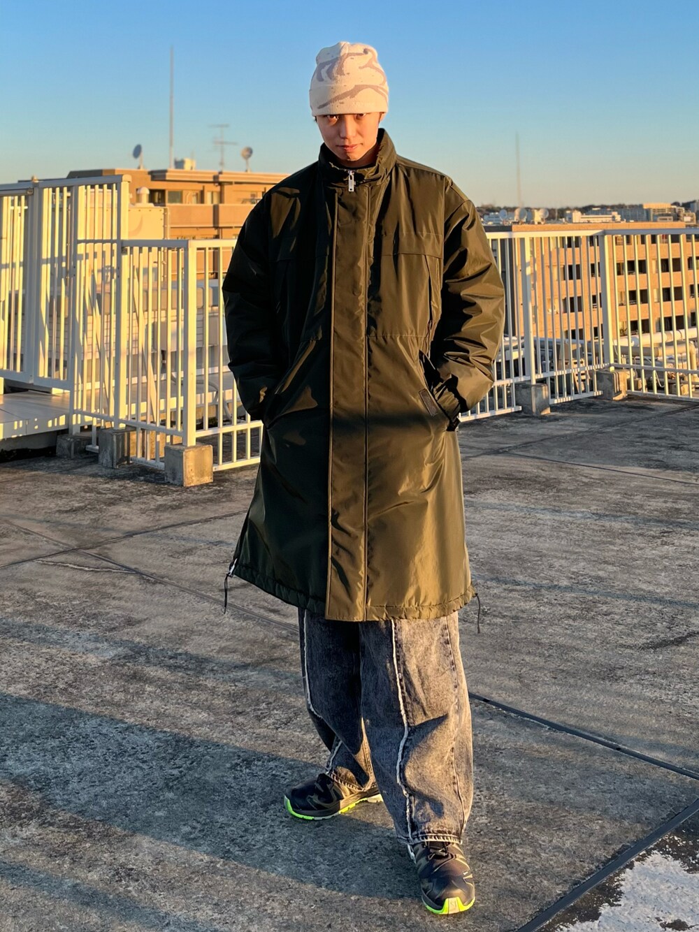 ブラック系のデニムパンツ、ブラック系のスニーカー、グリーン系のダウンジャケット/コートを着用したメンズの冬コーディネートの1枚目の写真