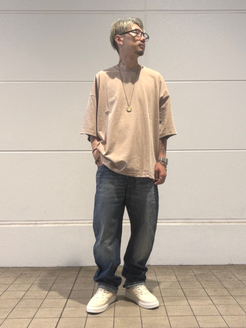 ベージュ系のTシャツ/カットソー、ブルー系のデニムパンツを着用したメンズの秋コーディネートの1枚目の写真