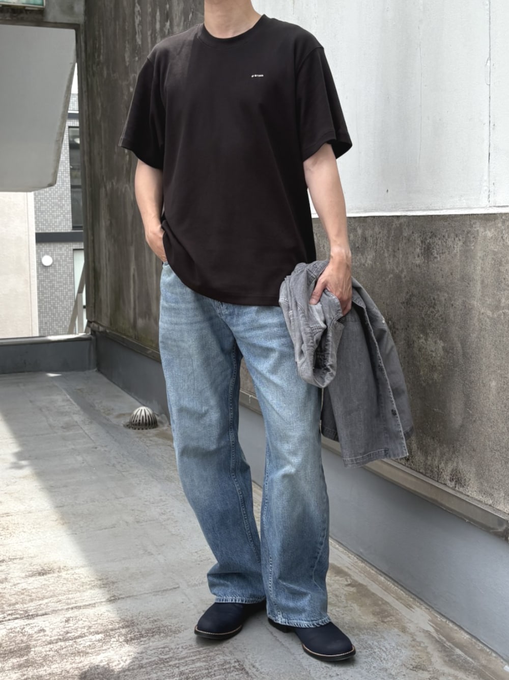 ブラック系のTシャツ/カットソー、ブルー系のデニムパンツを着用したメンズの夏コーディネートの1枚目の写真