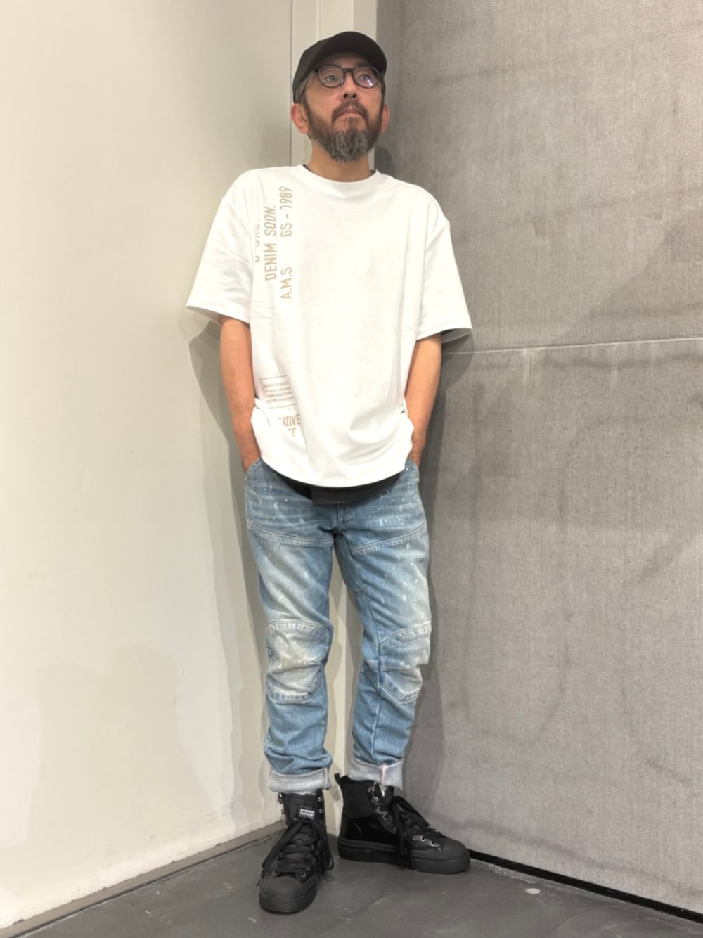 ホワイト系のTシャツ/カットソー、ブルー系のデニムパンツ、ブラック系のスニーカーを着用したメンズの夏コーディネートの1枚目の写真