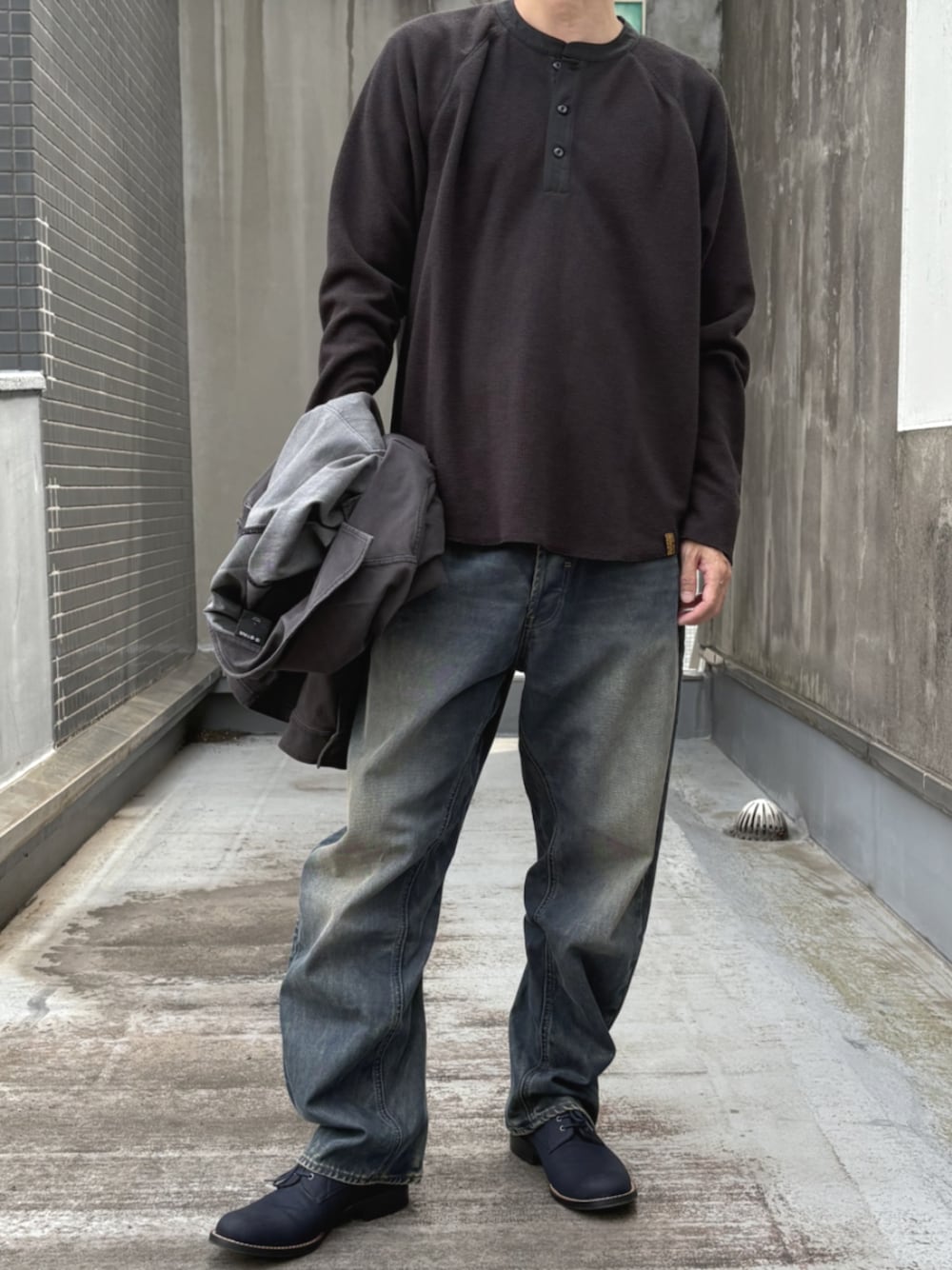 ブラック系のTシャツ/カットソー、ブルー系のデニムパンツを着用したメンズの秋コーディネートの1枚目の写真