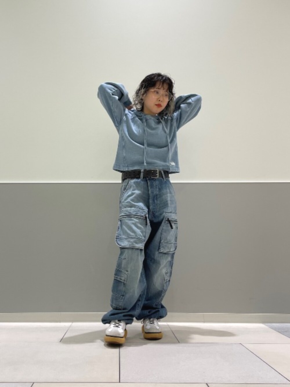 ブルー系のパーカー、ブルー系のデニムパンツを着用したレディースの春コーディネートの1枚目の写真