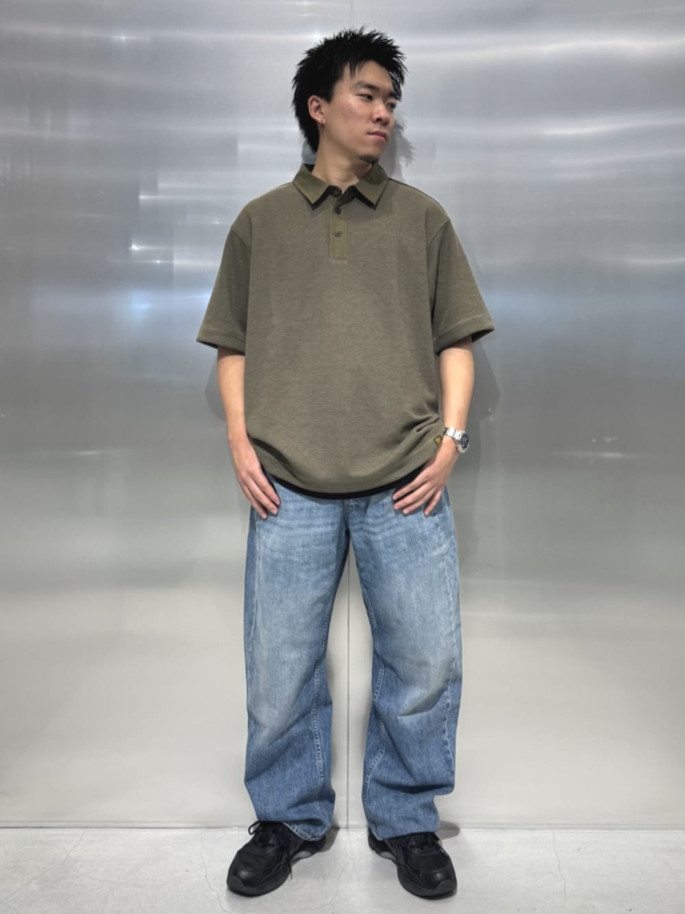 ブルー系のデニムパンツ、グリーン系のポロシャツを着用したメンズの夏コーディネートの1枚目の写真