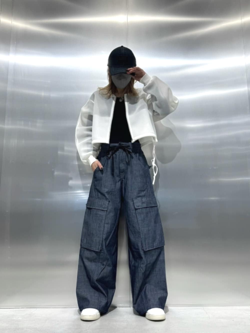ホワイト系のブルゾン、ブルー系のデニムパンツを着用したレディースの春コーディネートの1枚目の写真