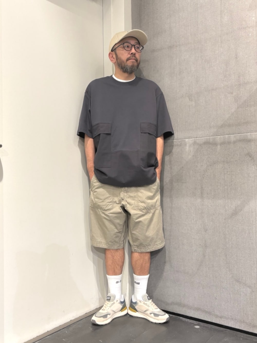 グレー系のTシャツ/カットソー、ベージュ系のその他パンツ、グレー系のキャップを着用したメンズの夏コーディネートの1枚目の写真