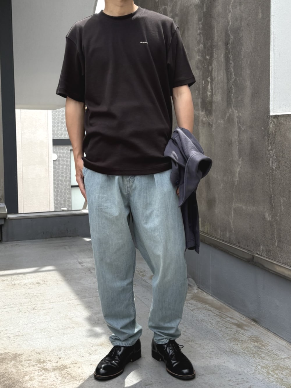 ブルー系のデニムパンツ、ブラック系のTシャツ/カットソーを着用したメンズの夏コーディネートの1枚目の写真