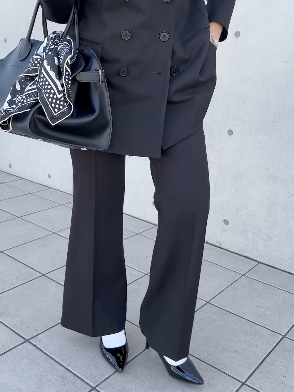 ブラック系のパンプスを着用したレディースの秋コーディネートの1枚目の写真