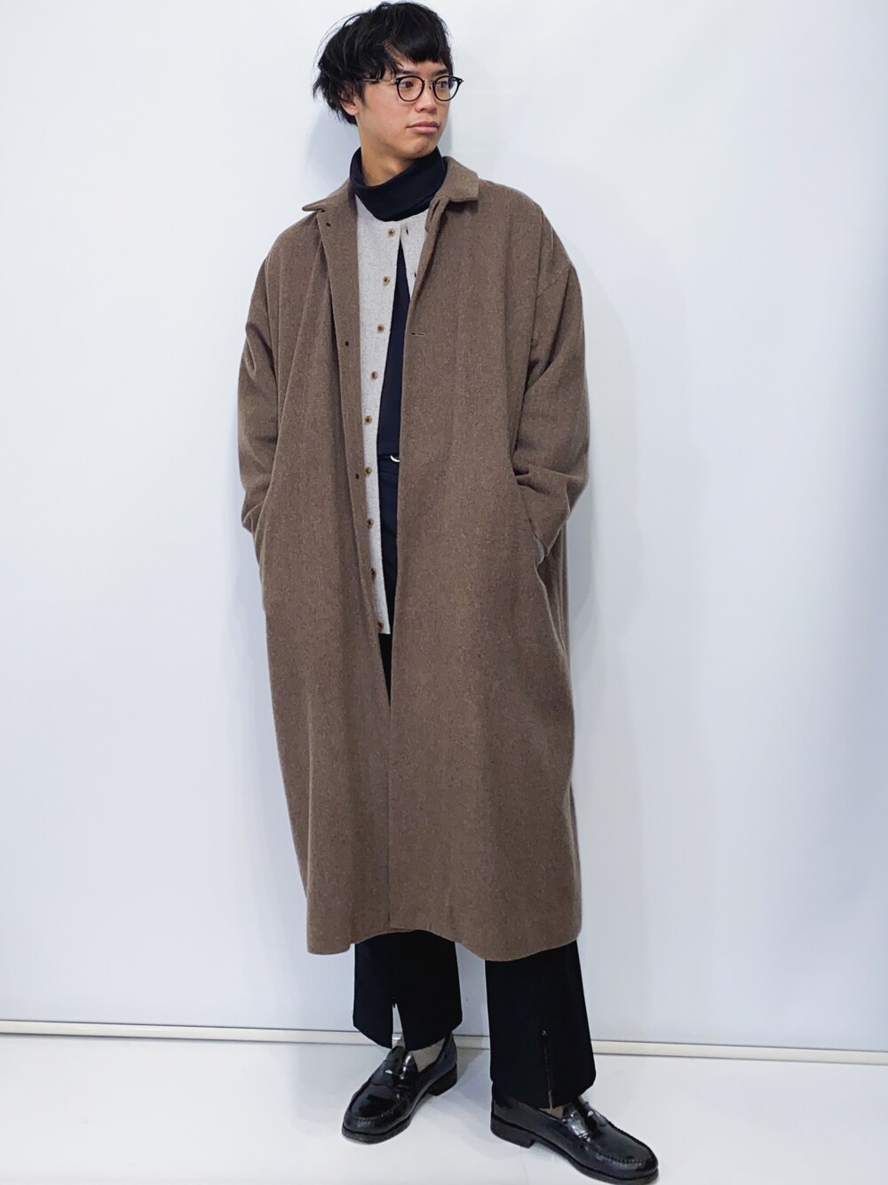 ベージュ系のカーディガン/ボレロ、ブラウン系のステンカラーコート、ブラック系のその他パンツを着用したメンズの冬コーディネートの1枚目の写真