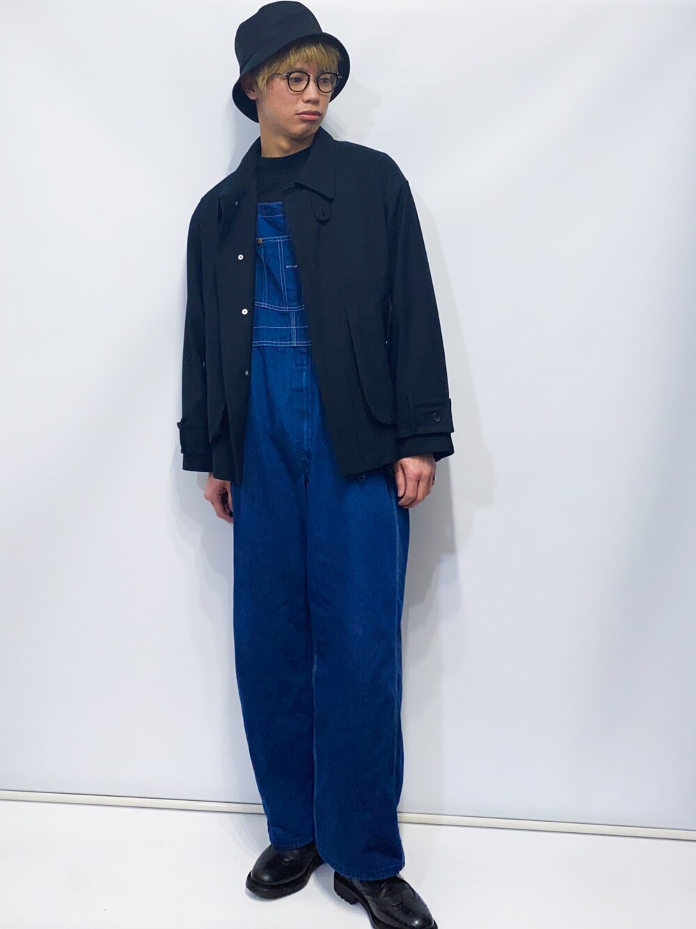 ブラック系のブルゾン、ブルー系のサロペット/オーバーオール、ブラック系のドレスシューズを着用したメンズの春コーディネートの1枚目の写真