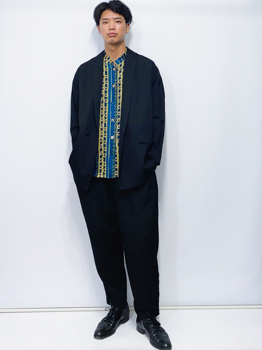 ブラック系のテーラードジャケット、ブラック系のスラックス、ブラック系のドレスシューズを着用したメンズの秋コーディネートの1枚目の写真