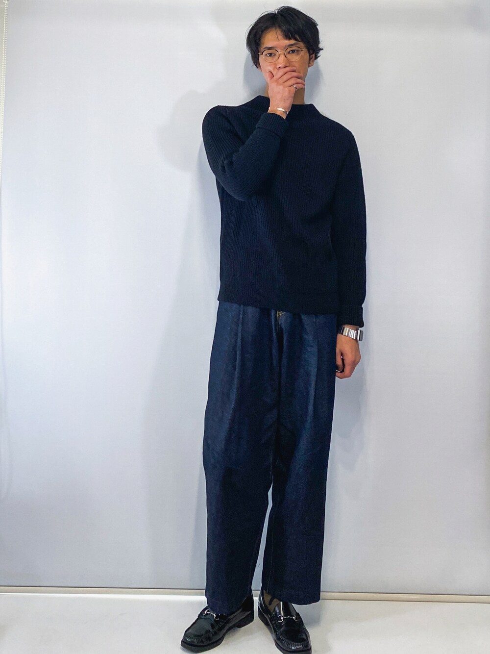 ブラック系のニット/セーター、ブルー系のデニムパンツ、ブラック系のローファーを着用したメンズの秋コーディネートの1枚目の写真