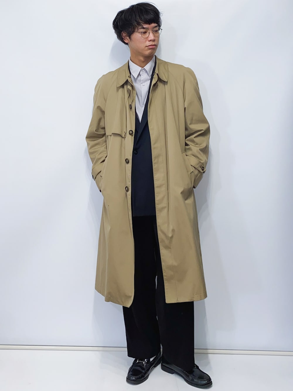 ブラック系のローファー、ブラック系のその他パンツ、ベージュ系のトレンチコートを着用したメンズの冬コーディネートの1枚目の写真