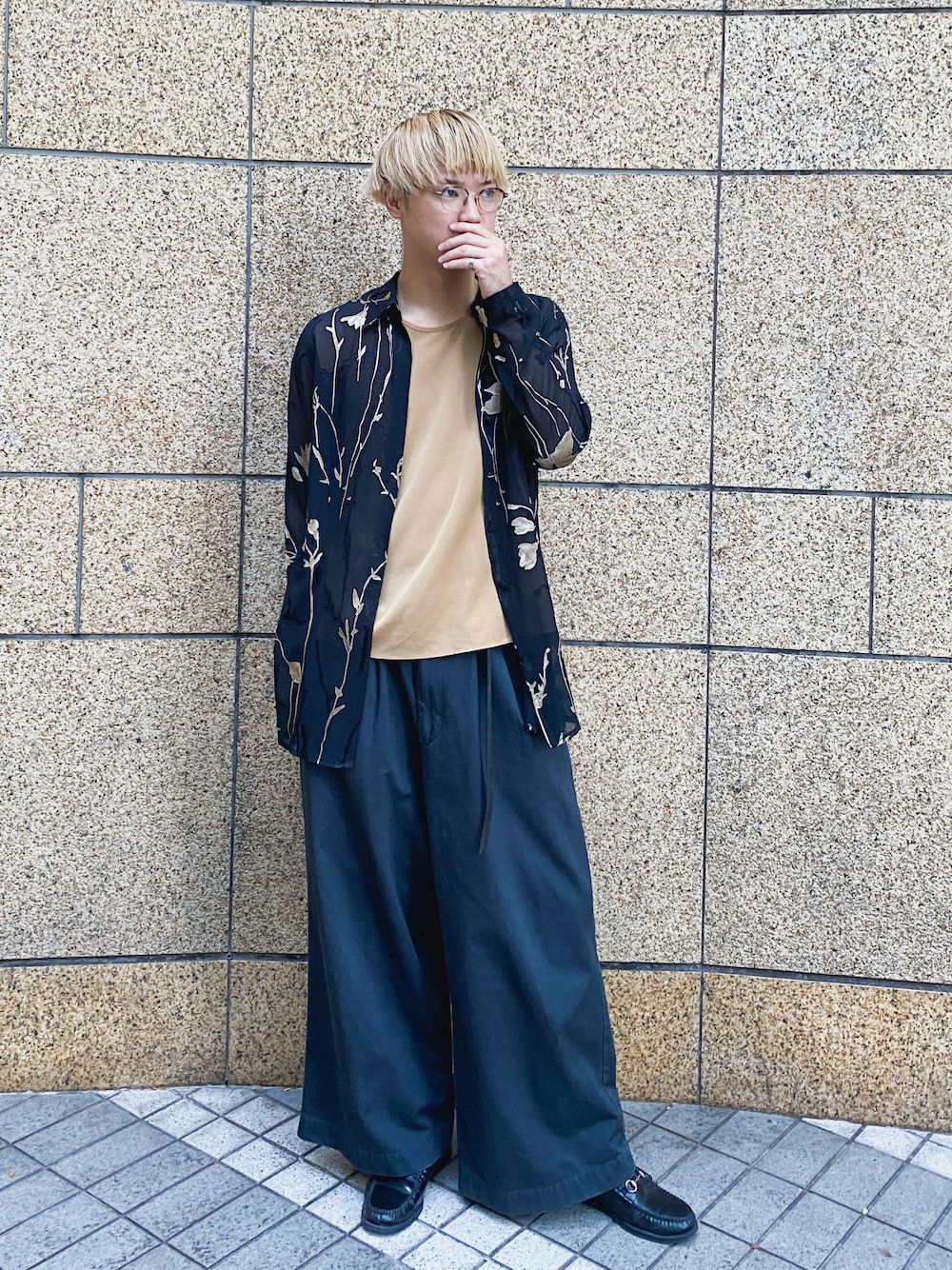 グレー系のチノパンツ、ブラック系のローファー、ブラウン系のメガネを着用したメンズの秋コーディネートの1枚目の写真